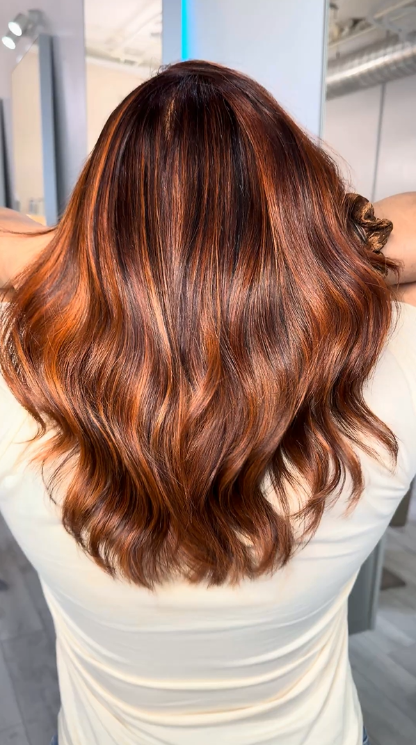 Persona con cabello castaño ondulado en un salón de belleza.