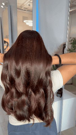 mujer mostrando su resultado final de cabello en salon