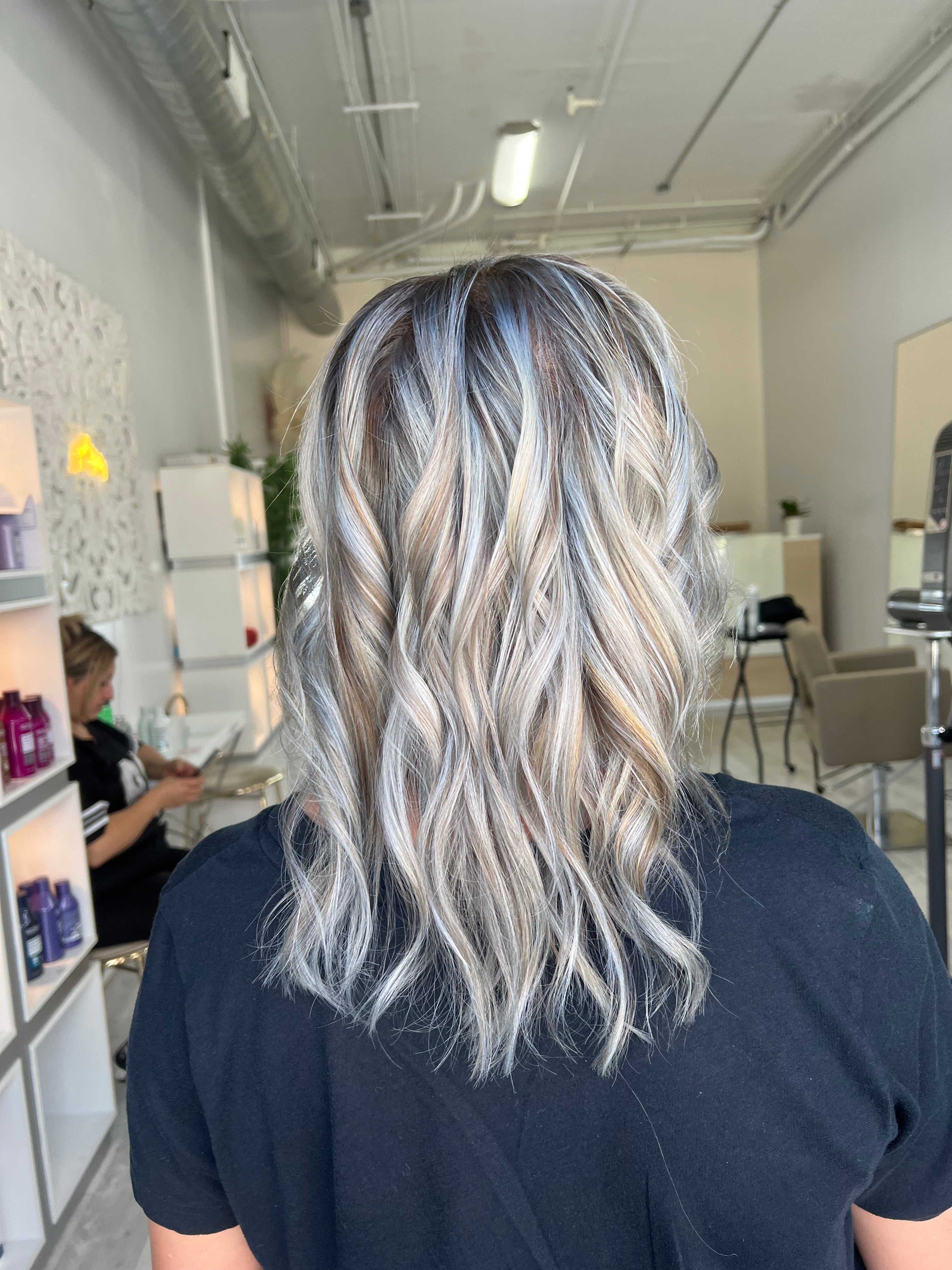 Persona con cabello plateado en un salón de belleza.