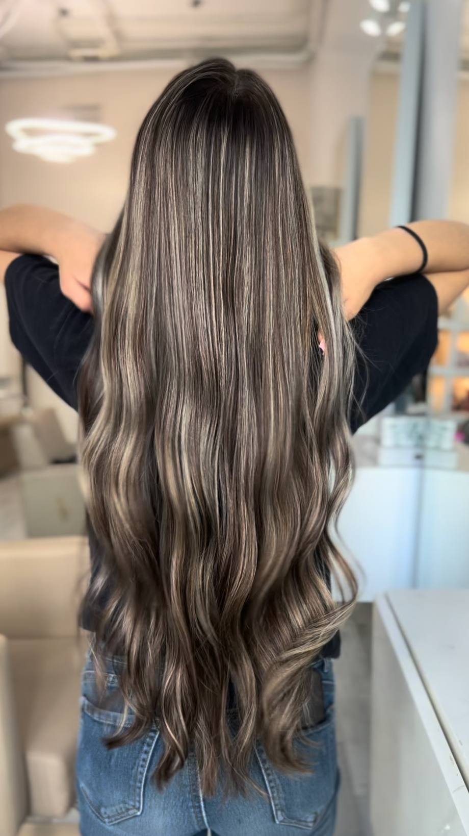 Persona con cabello largo y ondulado en un salón de belleza.